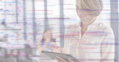 Tapping woman in light patterned blouse using tablet at office, data overlay, Stockfoto's
