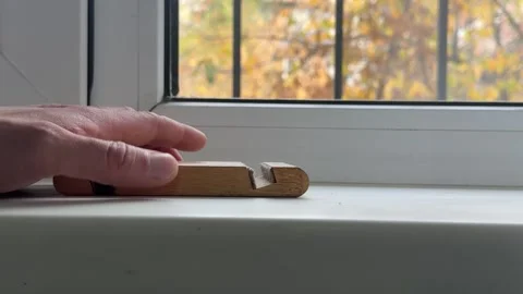 Tapping a wooden phone holder rhythmically on a windowsill Stock Footage 335074357