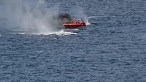 Target craft on fire with smoke billowing during live fire exercise Stock Footage 105572880