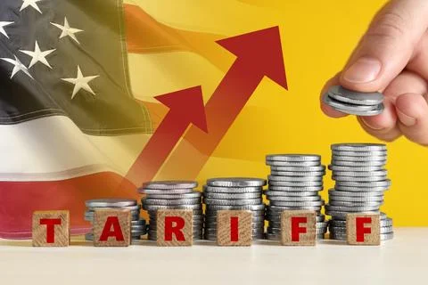 Tariff increase. Man stacking coins near cubes on table, closeup. Flag of U.. Foto stock