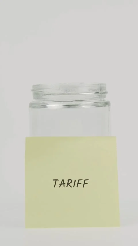 Tariff text or word on yellow sticky note attached to glass jar with hand Stock Footage 311794402