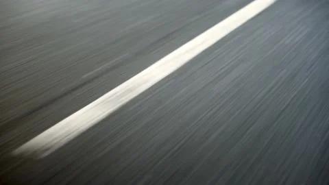 Tarmac road surface slow motion showing motion blur with white lines Stock Footage 166678356