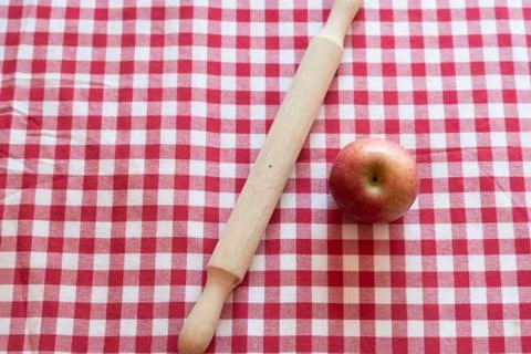 TarMaking a pie. Raw dough in a baking pan, rolling pin, apple and flour on t Stock Photos