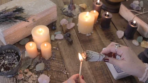 Tarot card reader lights a sage bundle and cleanses the reading with smoke. Stock Footage
