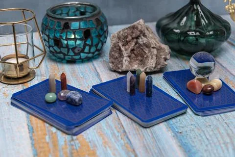 A tarot card reading setup with an array of colorful healing crystals on a .. Stock Photos