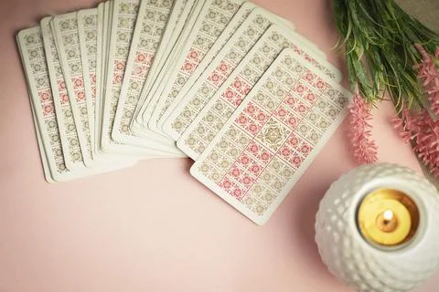 Tarot cards face down on table near burning candle, forecasting concept. Stock Photos