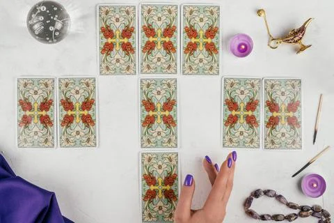 Tarot cards spread face down and female hand on white surface with crystal ba Stock Photos