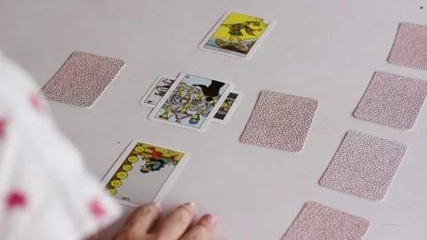 Tarot reader flipping cards of Celtic cross spread, over the shoulder shot Stock Footage 254181462