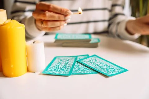 Tarot reader holding a burning match over tarot cards Stock Photos