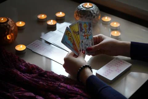 Tarot reader picking tarot cards, near burning candles. Stock Photos