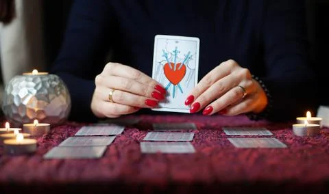 Tarot reader picking tarot cards near burning candles. Stock Photos