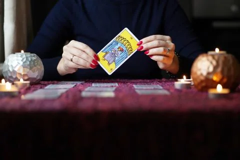 Tarot reader picking tarot cards near burning candles. Stock Photos