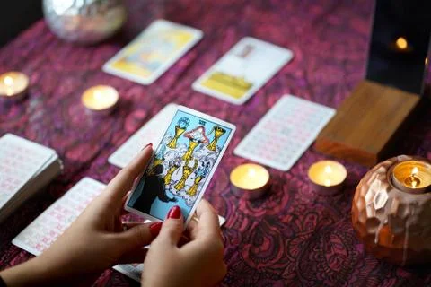 Tarot reader picking tarot cards near burning candles. Stock Photos