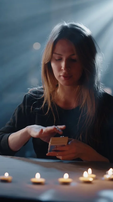 Tarot reader shuffling cards by candlelight Video stock 316824557