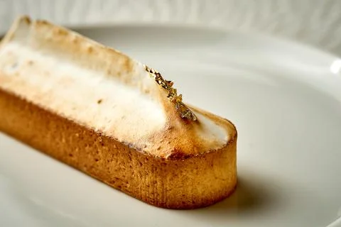 Tart with custard in a plate. Close-up. Selective focus. Noise added in post- Stock Photos