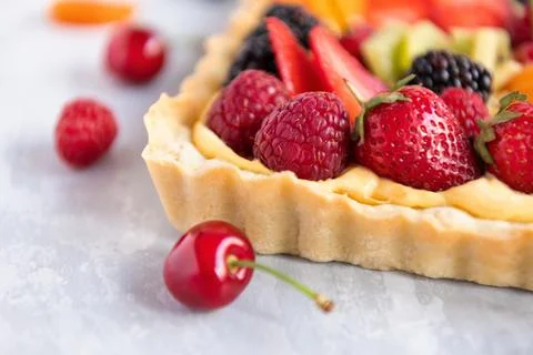 Tart with fresh fruit and creme patissiere on light blue background Foto stock