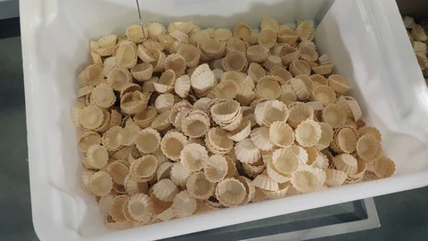 Tart waffle baskets fall into metal container for packing Stock Footage 124170136