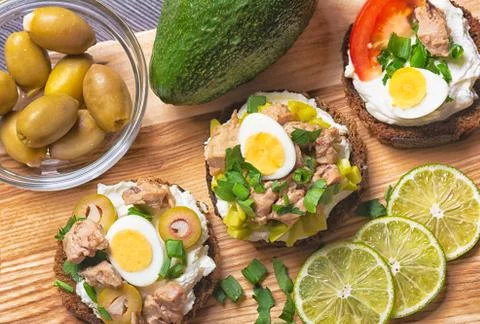 Tartki with cod liver on rye bread with olives and cream cheese. Stock-Fotos