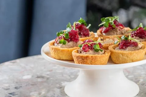 Tartlets stuffed with codfish liver, codfish caviar and microgreens. Traditional Stock Photos