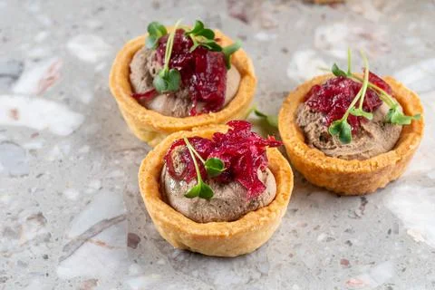 Tartlets stuffed with codfish liver, codfish caviar and microgreens. Traditional Stock Photos