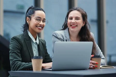 The task is lighter when the load is shared. two young businesswomen using a Foto stock