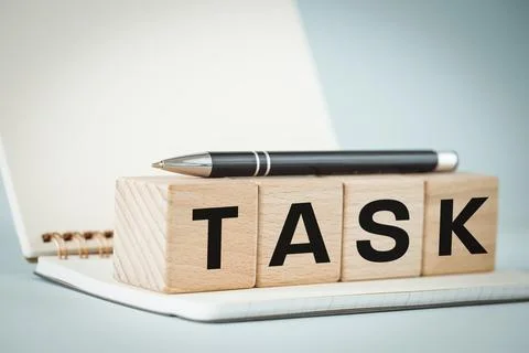 Task, office notebook, pen and wooden blocks with the word TASK Stock Photos