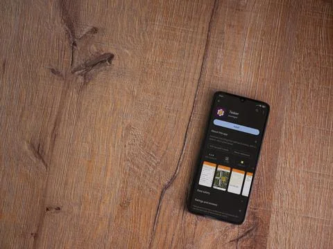 Tasker app play store page on smartphone on wooden background Stock Photos