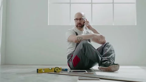 Taskmaster draws on tablet talking on mobile phone in room Stock Footage 149892419