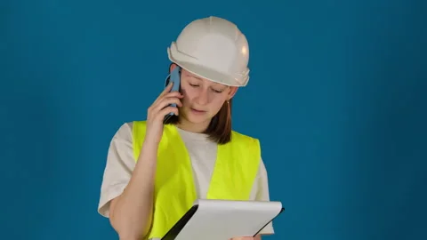 Taskmaster in hardhat gives instructions via cellphone Stock Footage 274632389