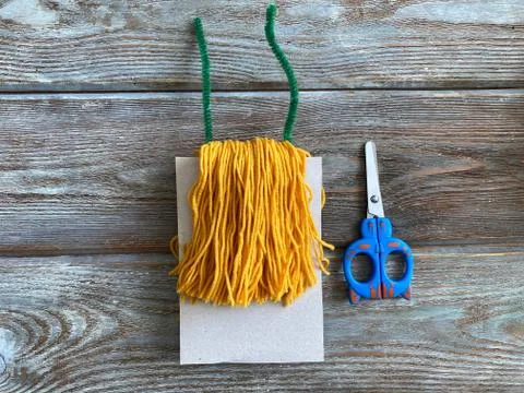 The tassel out of yellow yarn, a tutorial on how to make a monster, Stock Photos