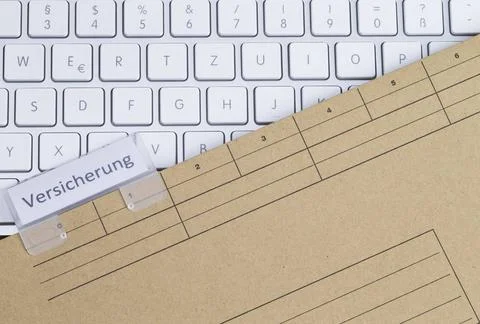  Tastatur und Aktenmappe Versicherung Das Foto zeigt ein weißes Keyboard m.. Stock Photos