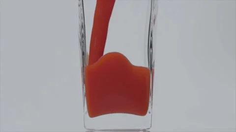 Taste it. Super slow motion shot of pouring tomato juice into a transparent Video stock 147413857
