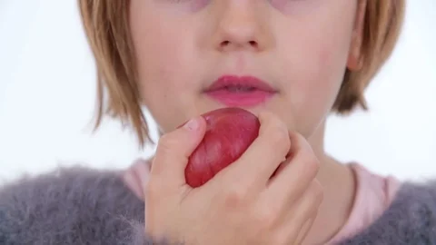 Tasting a bit of the red apple and then spitting it out Stock Footage 83724996