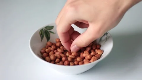 Tasting roasted peanuts from a plate 動画素材 71954301
