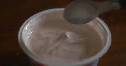 Tasting strawberry yogurt with spoon Stock Footage 70058721