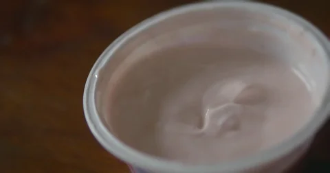 Tasting strawberry yogurt with spoon Stock Footage 70058859