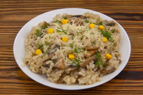 Tasty appetizing risotto on  white plate on  wooden table Foto stock