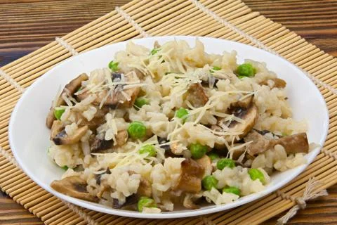 Tasty appetizing risotto on  white plate on  wooden background Stock Photos