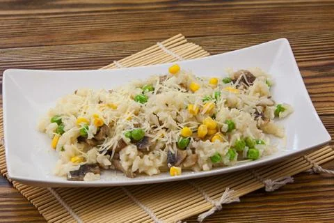 Tasty appetizing risotto on  white plate on  wooden background Stock Photos