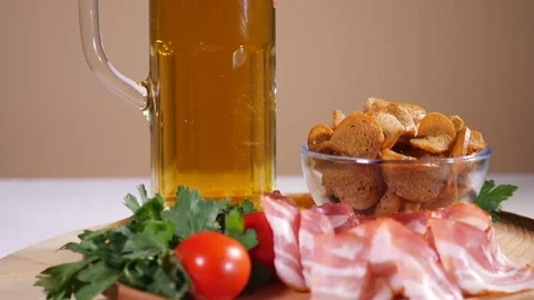 Tasty bread crackers, bacon, cherry tomatoes and a glass of beer Stock Footage 124375433
