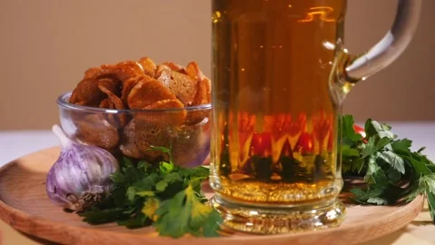 Tasty bread crackers, bacon, cherry tomatoes, greens and a glass of beer 1 Stock Footage 124376090