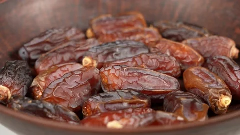 Tasty brown dried dates fruit isolated in brown bowl background Stock Footage 155874202