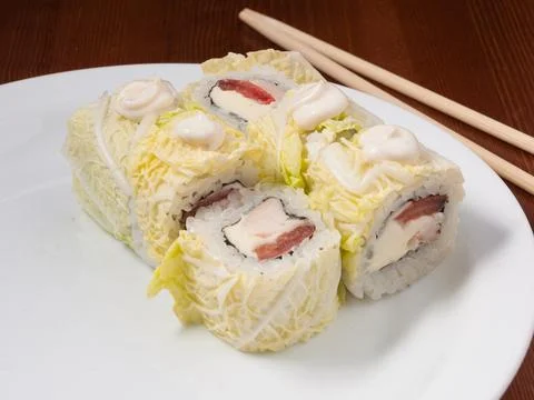 Tasty Caesar sushi roll on a white plate Stock Photos