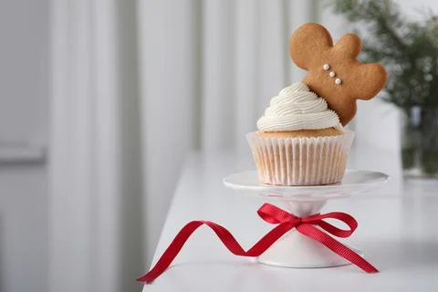 Tasty Christmas cupcake with cream and gingerbread man cookie on white table, Stock Photos