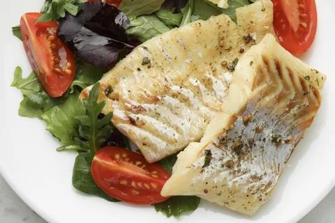 Tasty cod cooked served with salad on white table, top view Stock Photos