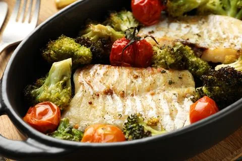 Tasty cod cooked with vegetables in baking dish, closeup Stock Photos
