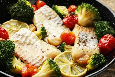 Tasty cod cooked with vegetables in frying pan, closeup Stock Photos