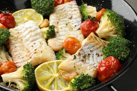 Tasty cod cooked with vegetables in frying pan, closeup Stock Photos