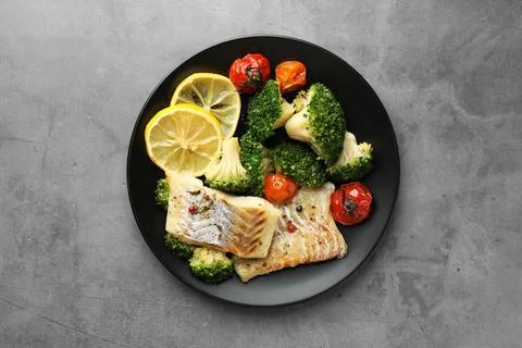 Tasty cod cooked with vegetables on grey table, top view Stock Photos