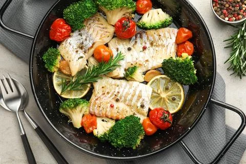 Tasty cod cooked with vegetables served on grey table, flat lay Stock Photos
